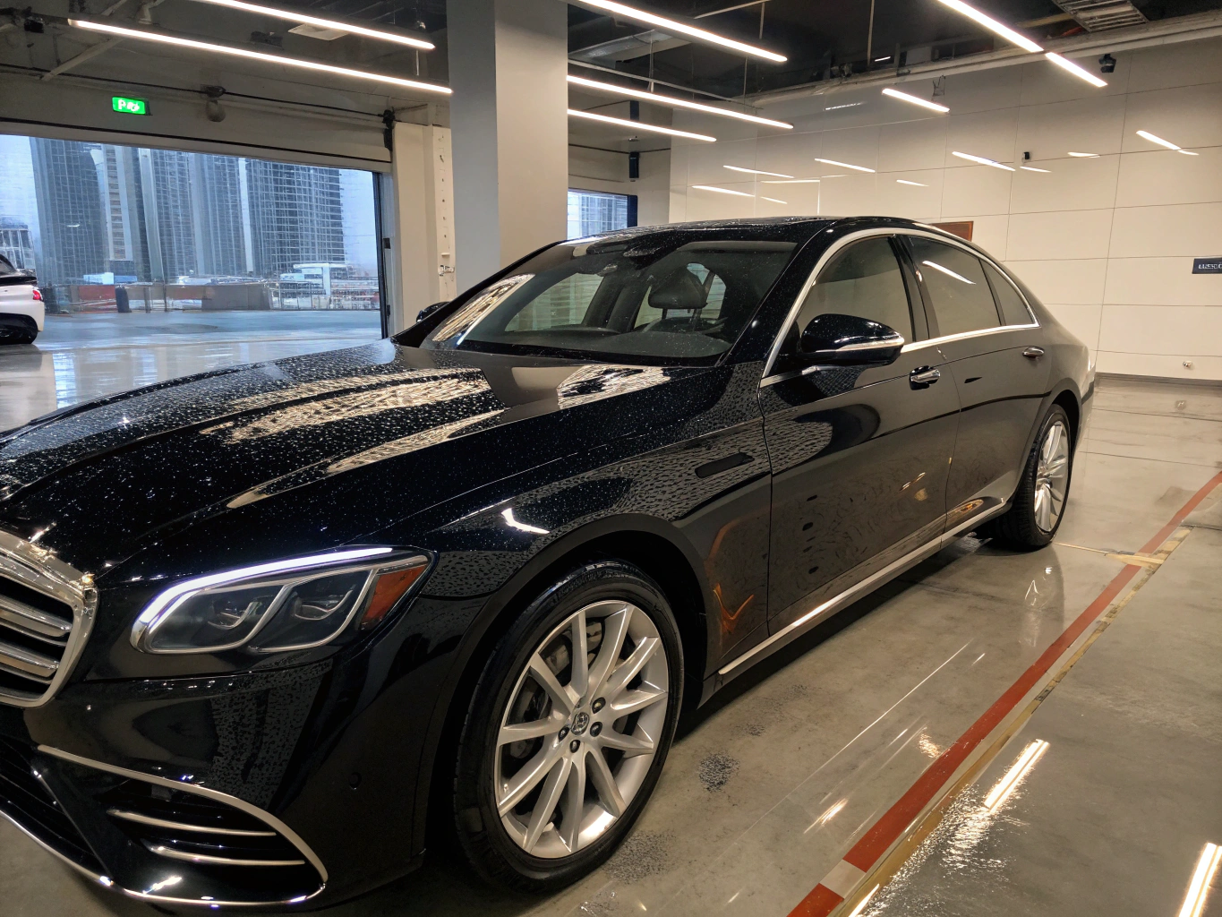 Restored black luxury sedan gleaming under shop lights